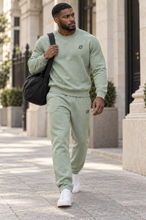 Man in de mintgroene ORION Crew Set loopt met een sporttas
