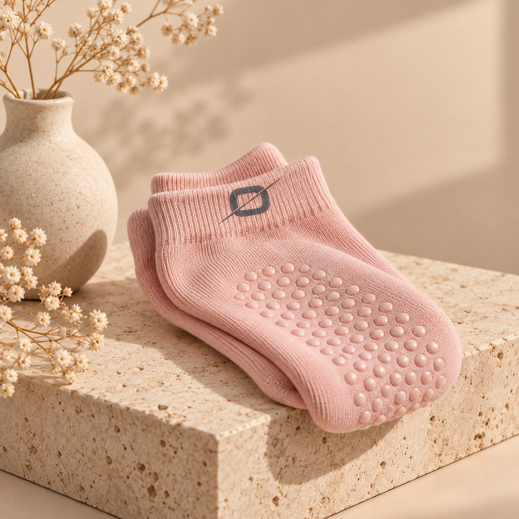 Roze ORION Grip Socks gevouwen op een stenen sokkel