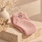 Roze ORION Grip Socks gevouwen op een stenen sokkel