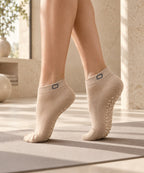 Zandkleurige ORION Grip Socks op een pilatesmat